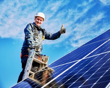 Photovoltaik Monteur auf einer Leiter